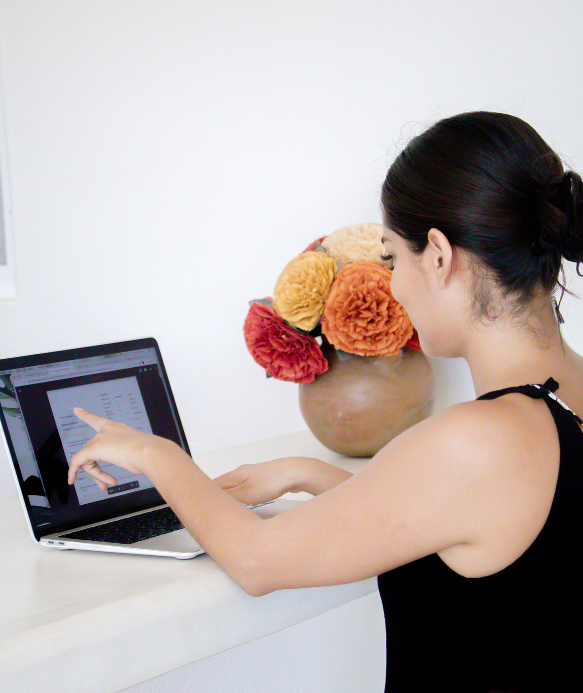 Woman Pointing on a Laptop Screen at Home